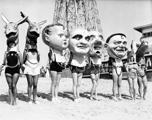 Women wearing oversized masks on the beach in Venice, ca.1930